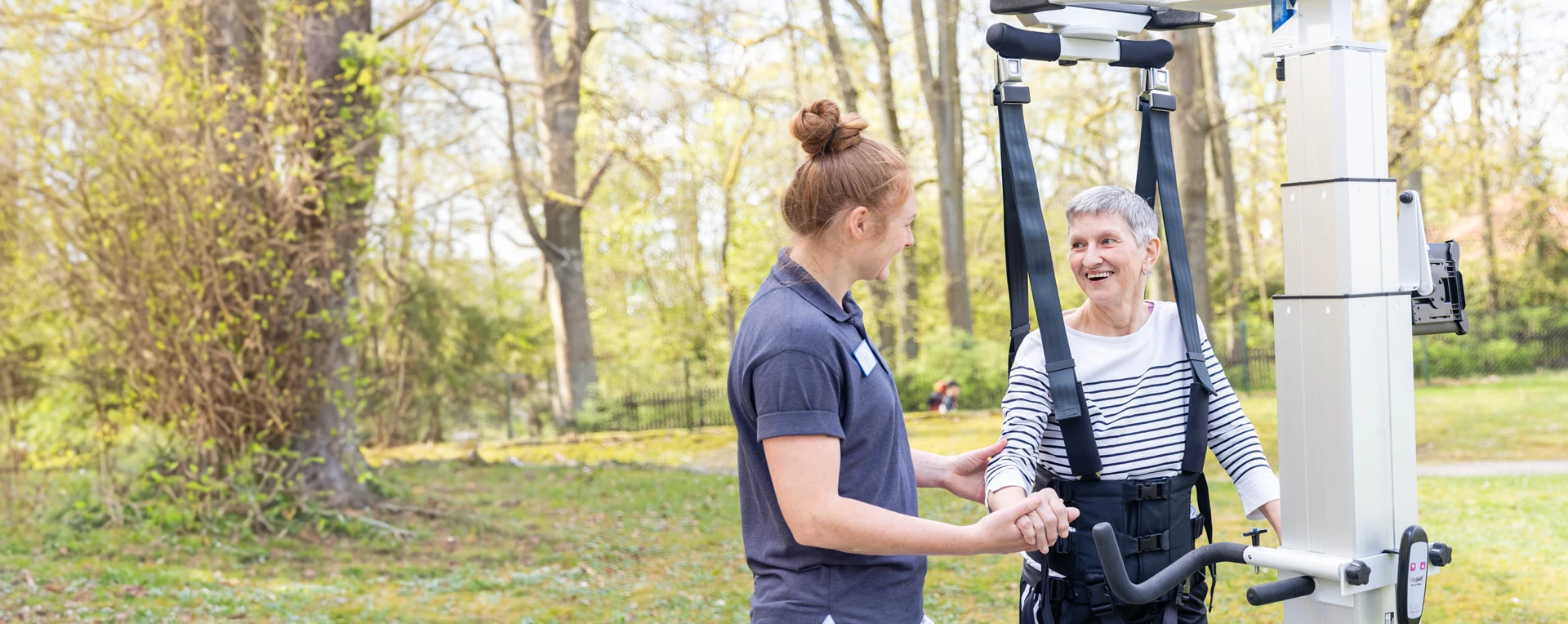 Eine Physiotherapeutin mit einer Patientin draußen in der DianaKlinik.